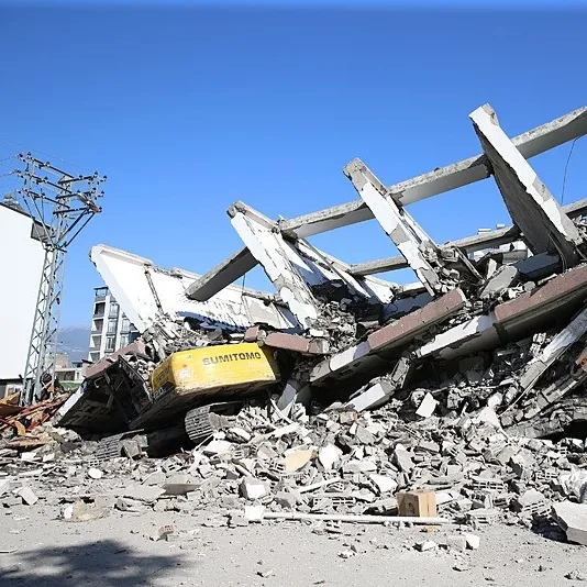 7 katlı bina iş makinesinin üzerine devrildi