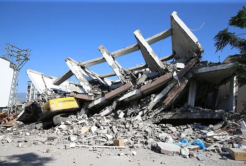 7 katlı bina iş makinesinin üzerine devrildi