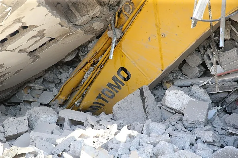 Hatay'da korku dolu anlar | 7 katlı bina yıkım sırasında iş makinesinin üzerine devrildi (AA)