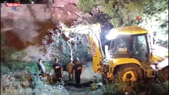 Düştüğü su kanalında çamura saplanan inek, kepçeyle kurtarıldı