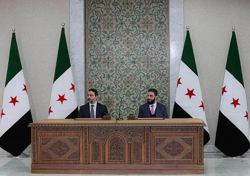 Başkent Şam'daki Halk Sarayı'nda düzenlenen törende, geçici anayasayı hazırlama komitesi üyelerinin yanı sıra Ulusal Diyalog Konferansı üyeleri, Suriye Müftüsü ve Suriye Alimler Birliği Başkanı Üsame Rıfai ile Suriye Dışişleri Bakanı Esad Hasan Şeybani (solda) yer aldı. (AA)
