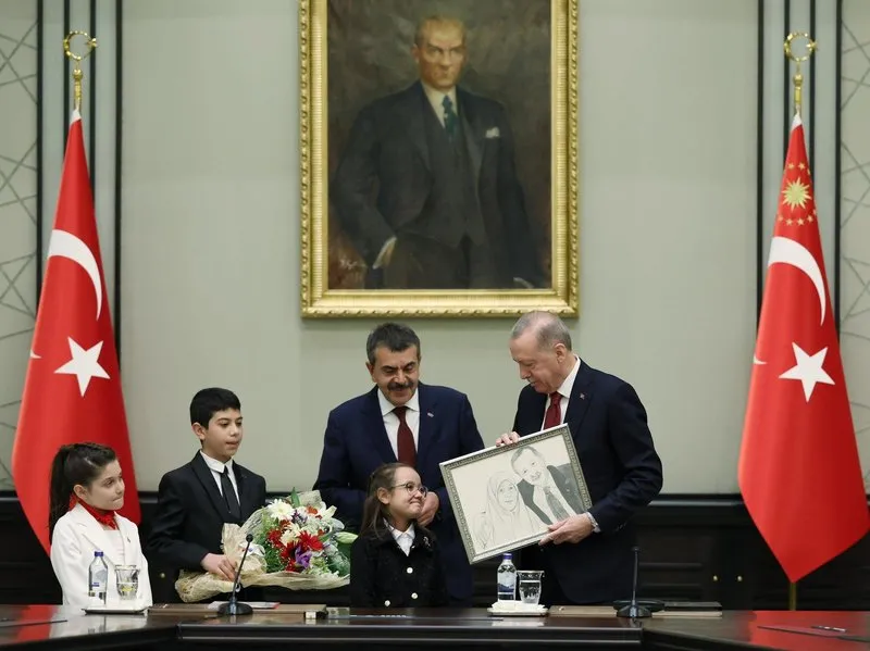 Çocuklardan Buğlem Yılmaz, Başkan Erdoğan'a annesi Tenzile Erdoğan ile birlikte çekilen fotoğrafının karakalem çizimini hediye etti. Erdoğan da çocuklara kol saati hediye etti.