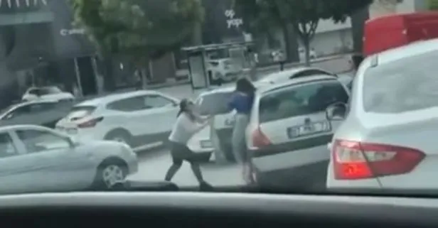 İki kadının trafikte otomobilin yanında saç saça baş başa kavga ettiği anlar