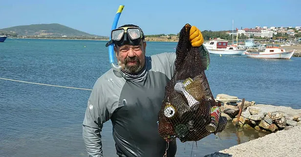 Balıkesir'in Ayvalık ilçesinde yaşayan emekli adam, 27 yıldır gönüllü olarak denizi temizliyor