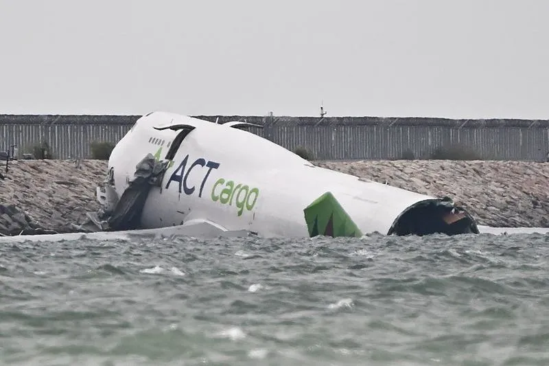 Hong Kong'a inişi sırasında pistten çıkan kargo uçağı denize sürüklendi. (AFP)
