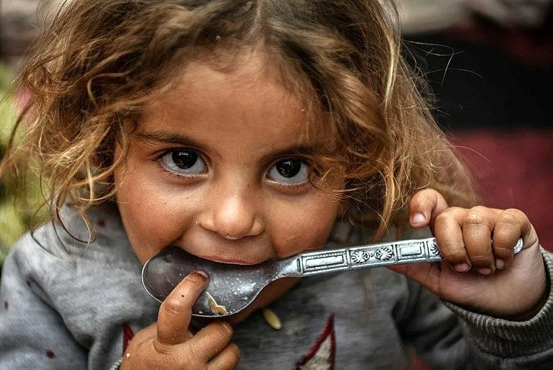 Saldırılar nedeniyle Refah kentine sığınan Filistinliler, hayır kurumlarının dağıttı yemeklerle karınlarını doyurmaya çalışıyor.