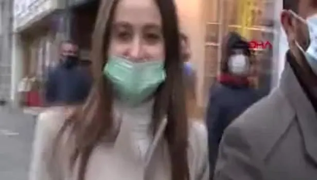 İstiklal Caddesi'nde maskesi burnunun altında olan bir kadın kameraları görünce poz verdi