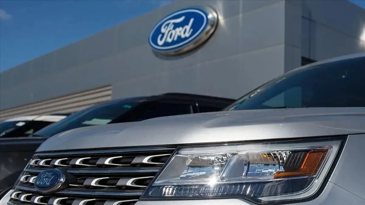 Ford mühendis ekibi üretim bandında çalışırken, oto galeri sektöründe insan uzmanlığının önemi.