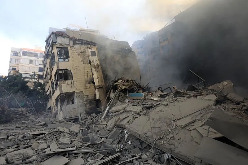 İsrail'in 3 Ekim 2024'te Beyrut'un güney banliyölerindeki El Jamous mahallesini hedef alan gece hava saldırısında vurulan binalardan dumanlar yükseliyor. (AFP)