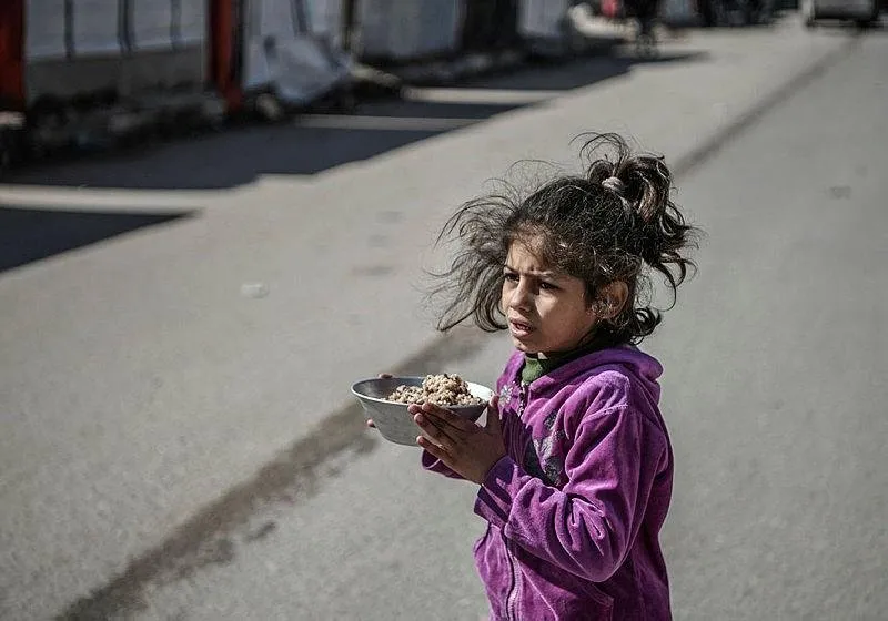 Saldırılar nedeniyle Refah kentine sığınan Filistinliler, hayır kurumlarının dağıttı yemeklerle karınlarını doyurmaya çalışıyor.