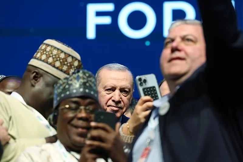 Başkan Erdoğan, konuşmasının ardından sahnede kendisiyle fotoğraf çektirmek isteyen katılımcılarla resim çektirdi. (AA)