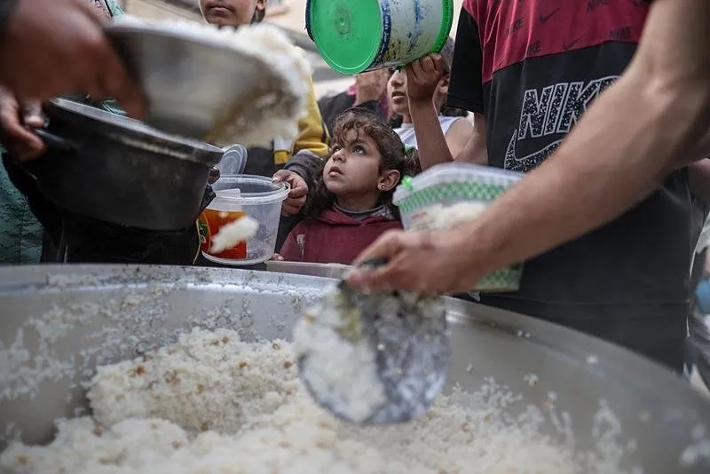 İsrail'in abluka altındaki Gazze Şeridi'ne yönelik saldırıları aralıksız sürerken bölgeye uyguladığı tam ambargo sebebiyle Filistinliler temel gıda malzemeleri dahil birçok hayati ihtiyacı temin etmekten aciz kalıyor. Deyr Balah kentindeki çocuklar, hayır kurumlarının dağıttığı yemeklerden ailelerine alabilmek için kuyrukta bekliyor. (2 Nisan 2024)