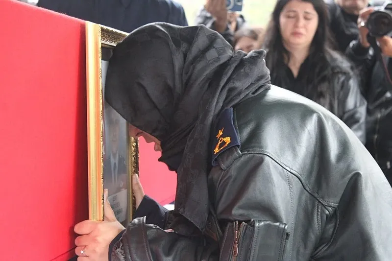 Şehidin eşi Ülkü Öztürk İlgen de şehit eşinin fotoğrafına bakarak gözyaşı döktü. (İHA)