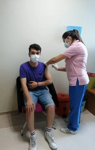 Sağlık Bakanı Fahrettin Koca Kovid-19'u yenen ancak babasını kaybeden hemşire Ebru Ulu'nun aşı yaparken fotoğrafını paylaştı