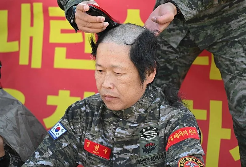 Bir gazi ve eşi saçını kazıttı (AFP)